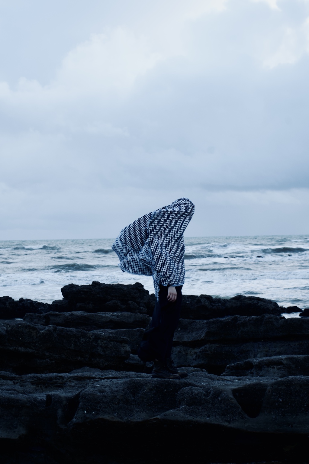 Dance with the Wind, figure concealed beneath patterned fabric on the shoreline