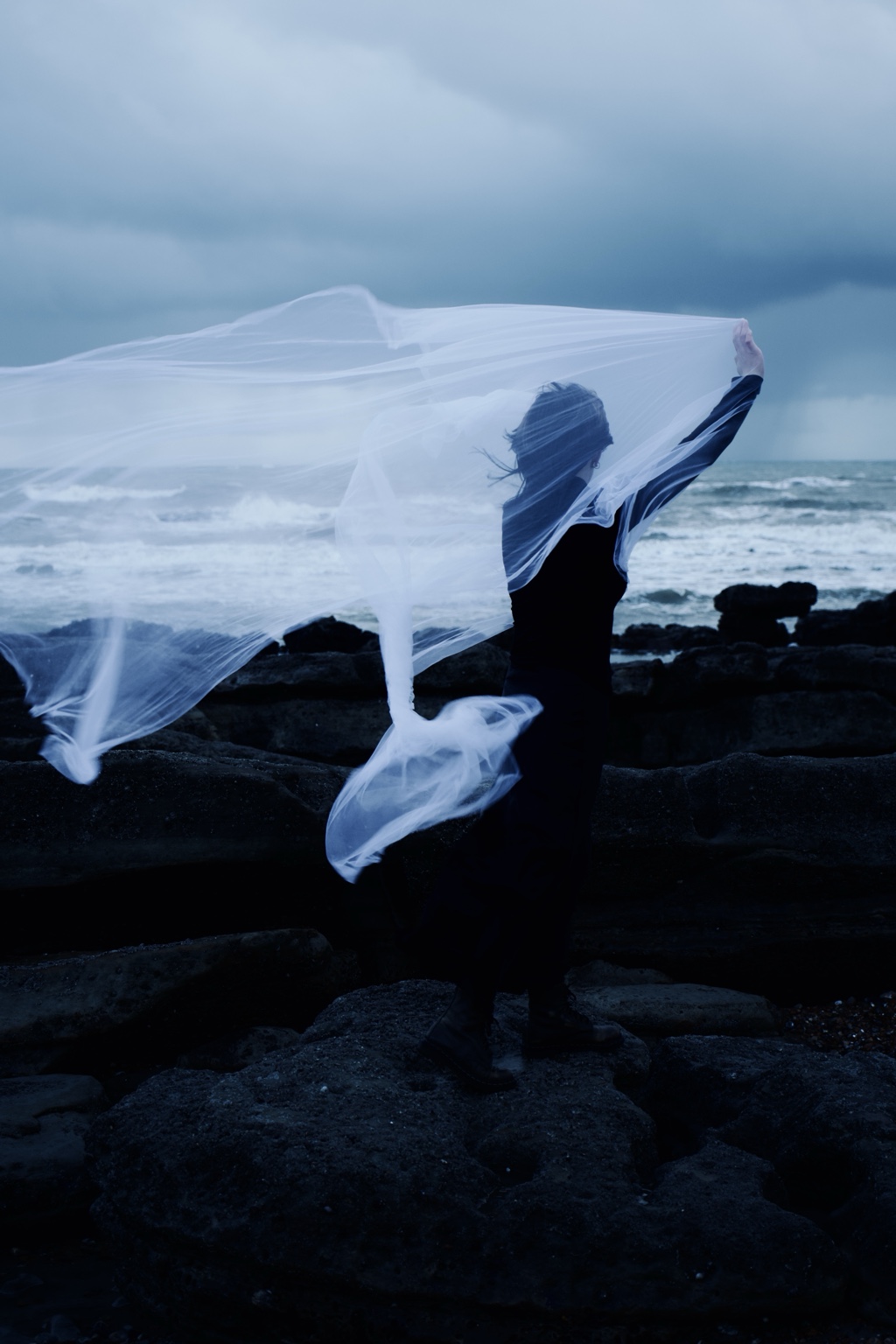Dance with the Wind, figure stretching translucent fabric outward in the wind