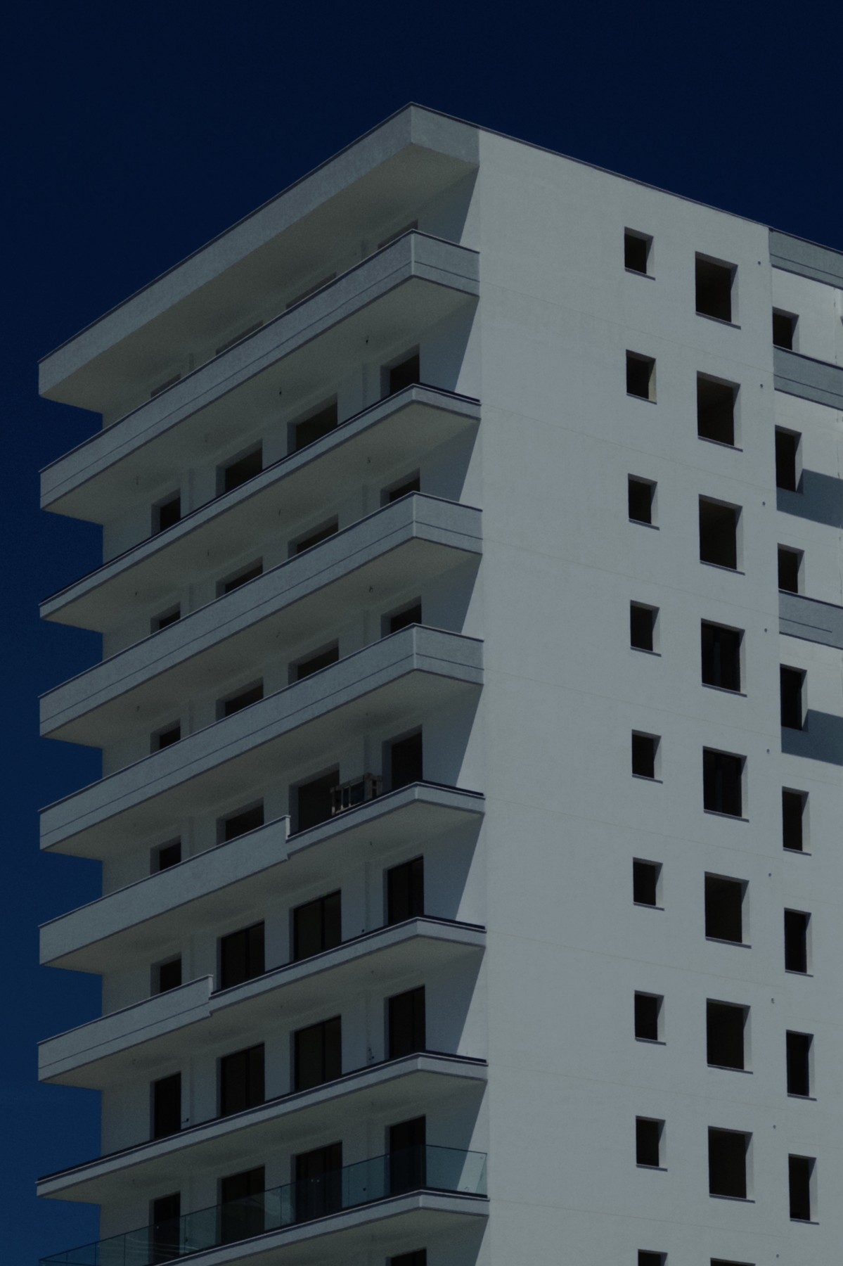 Gaze, white building with dark window openings against a blue sky