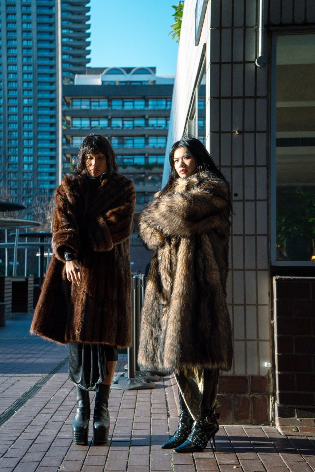 Two figures in fur garments standing within the city