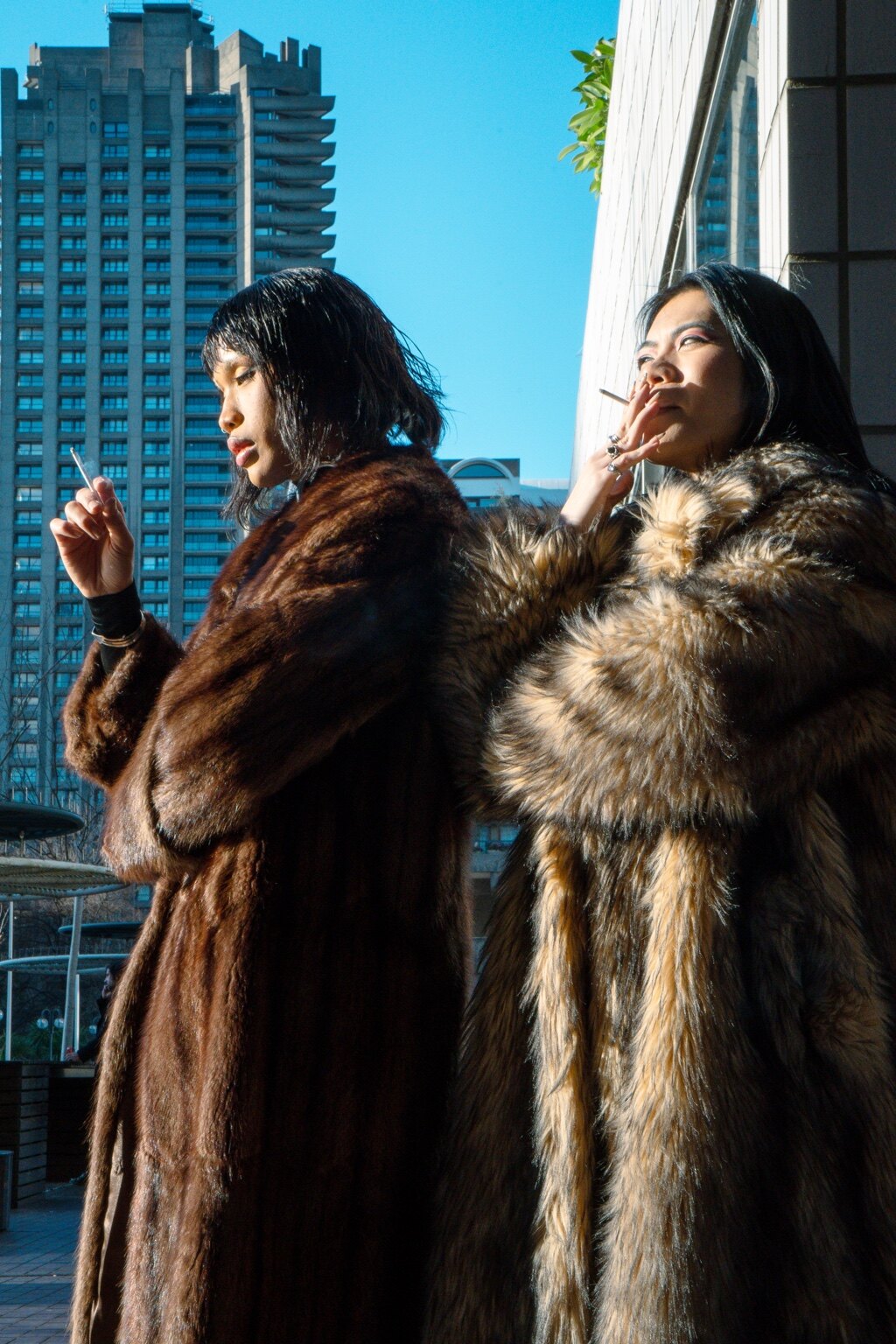 Two figures smoking against London architecture